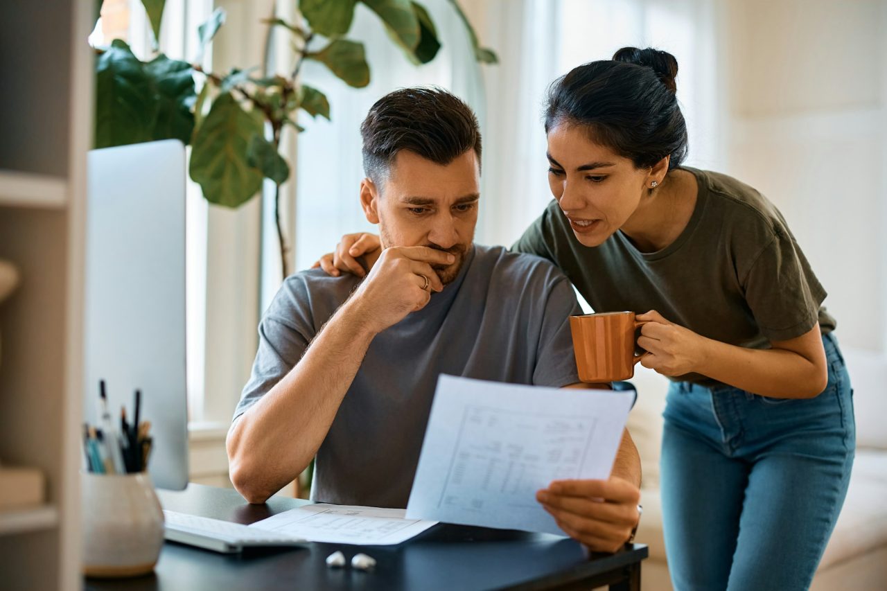 Mid adult couple analyzing their home finances at home .jpg